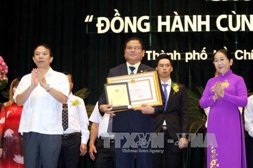 Phó Chủ tịch Tổng Liên đoàn Lao động Việt Nam Mai Đức Chính và Phó Bí thư Thành ủy Thành phố Hồ Chí Minh Võ Thị Dung trao bằng khen tuyên dương 34 doanh nghiệp điển hình trong chương trình "Đồng hành cùng doanh nghiệp” năm 2017. Ảnh: Thanh Vũ-TTXVN