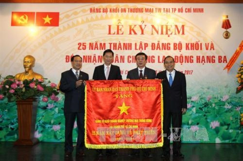 Phó Chủ tịch UBND Thành phố Hồ Chí Minh Trần Vĩnh Tuyến trao tặng Cờ của UBND Thành phố cho Đảng bộ Khối Doanh nghiệp Thương mại Trung ương tại Thành phố Hồ Chí Minh. Ảnh: Thanh Vũ-TTXVN