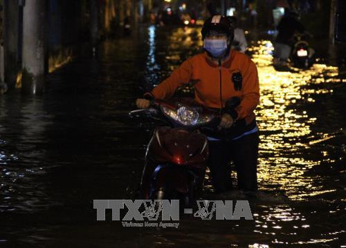Xe chết máy phải dẫn bộ trên đường Lê Văn Lương, huyện Nhà Bè. Ảnh: Xuân Dự - TTXVN