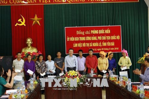 Đồng chí Phùng Quốc Hiển tặng cho các hộ dân bị thiệt hại do bão lũ ở thị xã Nghĩa Lộ. Ảnh: Đỗ Tuấn Anh-TTXVN