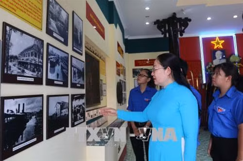 Bà Trần Thị Thu Trang, Trưởng Phòng Văn hóa - Thông tin quận 8 giới thiệu với đoàn viên thanh niên về cuộc đời sự nghiệp của Chủ tịch Tôn Đức Thắng tại Nhà tưởng niệm Bác Tôn trong khuôn viên Đình Bình Đông. Ảnh: Thanh Vũ-TTXVN