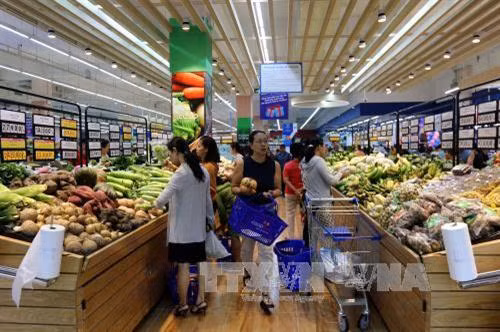 Người tiêu dùng chọn mua hàng tại siêu thị Co.opmart Huỳnh Tấn Phát. Ảnh: Thanh Vũ - TTXVN