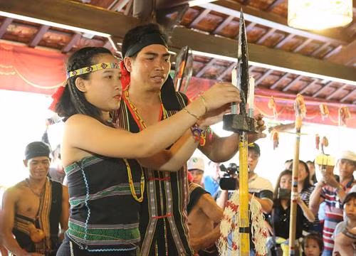 Đôi vợ chồng trẻ thực hiện nghi thức thổi và so đèn sáp, cây nào dài hơn thì người đó sống lâu hơn. Ảnh: Dương Giang - TTXVN