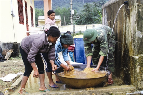 Bộ đội biên phòng hướng dẫn đồng bào ngâm thóc giống để gieo cấy vụ lúa mới