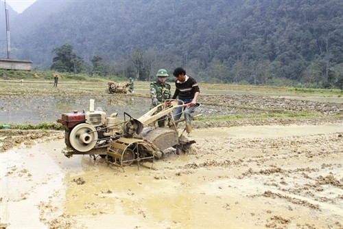 Bộ đội biên phòng hướng dẫn đồng bào sử dụng máy làm đất