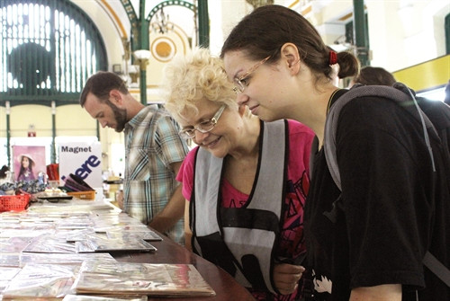 Du khách nước ngoài thích thú với những tấm bưu thiếp, tem, ảnh được trưng bày và giới thiệu tại các quầy hàng trong bưu điện.