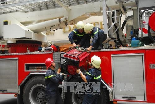 Xe chữa cháy và các thiết bị được điều động đến hiện trường dập lửa. Ảnh: Mạnh Linh-TTXVN