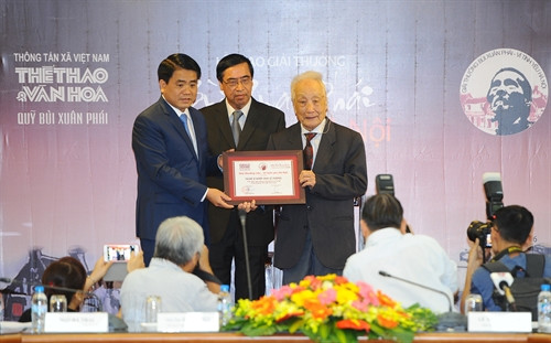 Chủ tịch UBND thành phố Hà Nội Nguyễn Đức Chung (ngoài cùng bên trái) trao Giải thưởng Lớn cho nghệ sỹ nhiếp ảnh Lê Vượng, ghi nhận những cống hiến, tình yêu của ông dành cho Thủ đô Hà Nội. Ảnh: Minh Đức- TTXVN