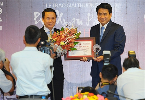 Tổng giám đốc TTXVN Nguyễn Đức Lợi (trái) trao giải "Ý tưởng- Vì tình yêu Hà Nội" cho Chủ tịch UBND thành phố Hà Nội Nguyễn Đức Chung.