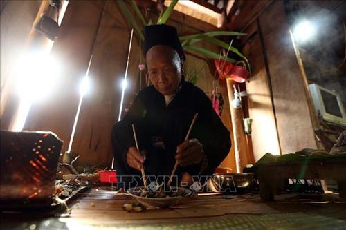 Thầy cúng chuẩn bị đồ lễ. Ảnh: Phan Tuấn Anh - TTXVN