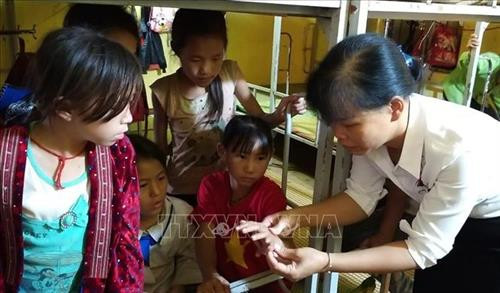 Giáo viên trường Phổ thông dân tộc bán trú Tiểu học Xá Nhè kiểm tra các vết ngứa của học sinh. Ảnh: TTXVN Giáo viên trường Phổ thông dân tộc bán trú Tiểu học Xá Nhè kiểm tra các vết ngứa của học sinh. Ảnh: TTXVN