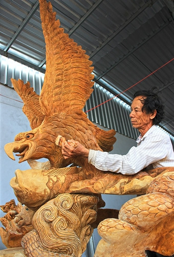 Người thợ tỉ mỉ chỉnh sửa tác phẩm vừa được hoàn thành sau hai tháng miệt mài chạm khắc.