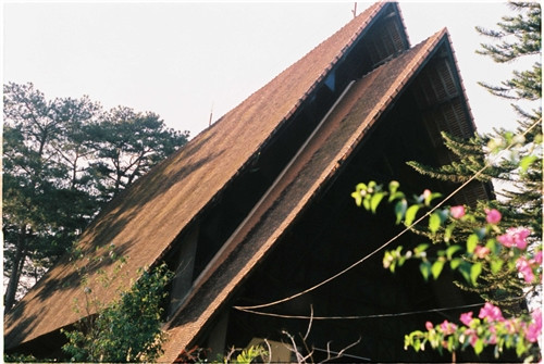 Nhà thờ Cam Ly hay còn gọi là nhà thờ Sơn Cước (đường Nguyễn Khuyến, phường 5, TP Đà Lạt) vừa cổ kính vừa mang trong mình câu chuyện riêng. Nhà thờ này đã được xây dựng và tồn tại 50 năm, trong quá trình hình thành gặp vô vàn khó khăn. Trước đây nhà thờ Cam Ly dành cho đồng bào dân tộc (chủ yếu là người K’ho) nhưng giờ mở rộng ra cho mọi người. Trước cổng nhà thờ có hình hổ và đại bàng, tượng trưng cho sức mạnh, sự bảo vệ và vươn xa. Đường dẫn vào nhà thờ tràn ngập những loài hoa nhỏ xinh. Mái công được xây bằng loại gạch màu cũ xưa theo hình nhà tháp, giống cấu trúc nhà rông của đồng bào Tây Nguyên. Khi bước vào trong nhà thờ, bạn sẽ nhận thấy tràn ngập màu sắc với hình tam giác và hình chữ nhật. Người ta quan niệm hình tam giác tượng trưng cho Yàng - đấng tối cao của đồng bào, cũng là chúa Jesus. Hình vuông là quan niệm vũ trụ, trái đất là trung tâm và mọi thứ xoay quanh Trái đất. Phần đầu của nhà thờ cũng được xây dựng trong các khung hình màu sắc, hình Cha đặt làm trung tâm. Điều đặc biệt là trong nhà thờ này, dưới bức tượng của Cha, người ta đặt một cái đầu trâu với ý nghĩa trâu là loài động vật lành tính, siêng năng và trung thành, mong con người cũng hướng về những điều đó. Hơn 60 em nhỏ đang được nuôi dạy tại đây, có em mồ côi, có em được mẹ gửi vào. Mỗi ngày các em vui chơi, học tập, chiều đến thì vào nhà thờ đọc kinh. Nhà thờ Cam Ly không được nhiều người biết đến, bởi con người ở đây cũng sống tương đối ẩn dật. Mang trong mình nét màu sắc kiến trúc riêng, những thiết kế, trưng bày đều mang ý nghĩa riêng, nhà thờ Cam Ly vừa cũ vừa mới lại vừa ấm áp tình người. Nhà thờ Cam Ly (chấm đỏ) trên bản đồ. Ảnh: Google Map.