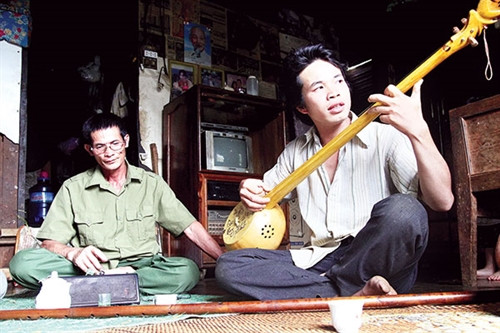 Cha con ông Lăng Văn Hợp và Lăng Văn Chi chơi đàn tính do Chi làm tặng cha