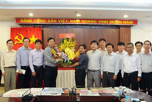 Bí thư Thành ủy TP. Hồ Chí Minh Đinh La Thăng tặng hoa chúc mừng cán bộ, phóng viên cơ quan TTXVN khu vực phía Nam. Ảnh: An Hiếu-TTXVN