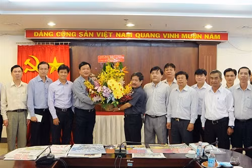 Bí thư Thành ủy TP. Hồ Chí Minh Đinh La Thăng tặng hoa chúc mừng cán bộ, phóng viên cơ quan TTXVN khu vực phía Nam. Ảnh: An Hiếu-TTXVN