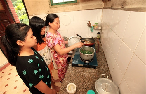 Mẹ Khuất Thị Loan, nhà Hoa Lay Ơn hướng dẫn các con gái cách nấu cơm canh tại gia đình.