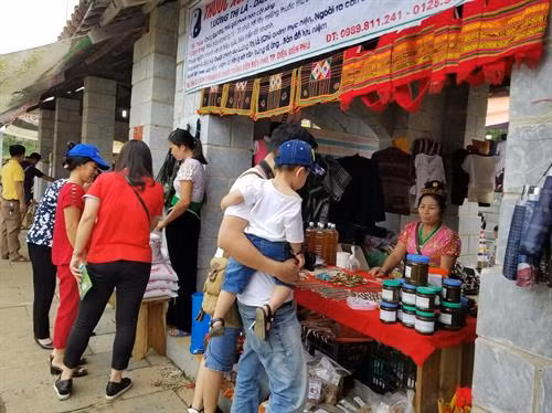 Du khách mua sắm đồ lưu niệm đặc trưng của đồng bào dân tộc vùng cao. Ảnh Hoàng Tâm