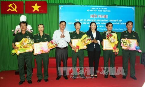 Trao tặng Bằng khen cho tập thể và cá nhân có thành tích xuất sắc trong thực hiện Chương trình phối hợp giữa Hội Nông dân Thành phố và Bộ đội Biên phòng Thành phố trong giai đoạn 2012-2016. Ảnh: Xuân Khu - TTXVN