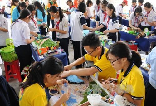 Các học sinh tham gia phần thi ghép tranh nổi từ những nguyên liệu thực vật tái chế. Ảnh: An Hiếu - TTXVN