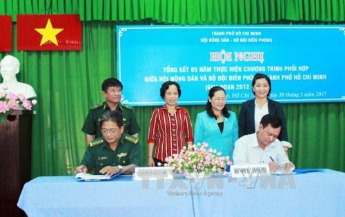 Đại tá Nguyễn Duy Thắng (trái), Phó Chính ủy Bộ đội Biên phòng Thành phố, và ông Trần Trường Sơn, Phó Chủ tịch Hội Nông dân Thành phố, ký Chương trình phối hợp hoạt động giai đoạn 2017-2021. Ảnh: Xuân Khu - TTXVN