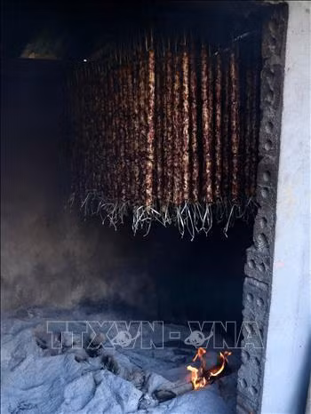 Sau khi được nhồi thịt, lạp xưởng được đem treo lên bếp. Ảnh: Quốc Khánh – TTXVN