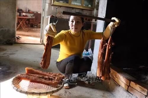 Sau khi tấm ướp đủ gia vị, những miếng thịt được đem treo lên bếp. Ảnh: Quốc Khánh – TTXVN