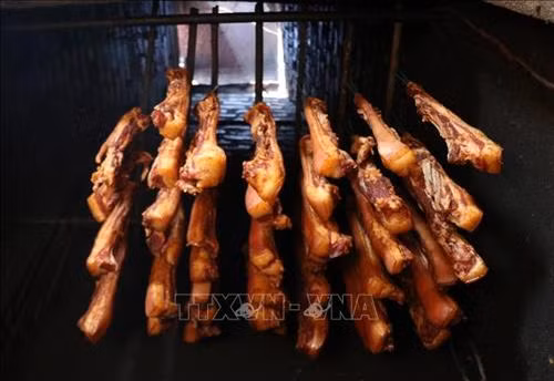 Sau khi tấm ướp đủ gia vị, những miếng thịt được đem treo lên bếp. Ảnh: Quốc Khánh – TTXVN