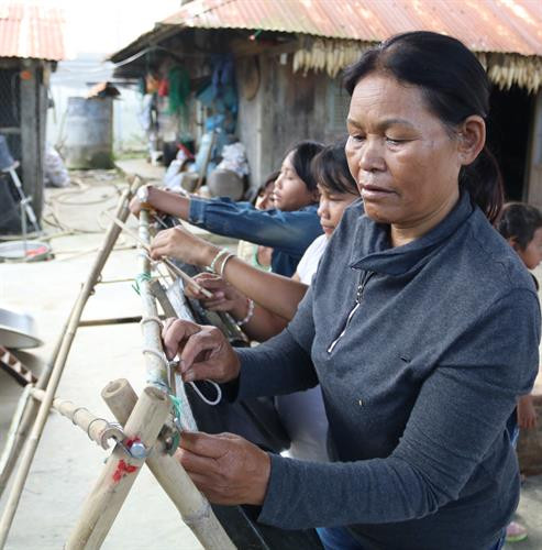Bà Mabio dạy các em thiếu nhi treo chiêng, chỉnh chiêng sao cho chuẩn, cho hay