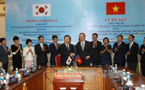 Phó Chủ tịch UBND Tp.Hồ Chí Minh Lê Văn Khoa cùng Phó Thị trưởng thứ nhất Tp.Seoul Gyoung-Gee Liu thực hiện nghi thức ký kết thỏa thuận về thiết lập quan hệ hữu nghị và hợp tác giữa hai thành phố. Ảnh: Thanh Vũ-TTXVN