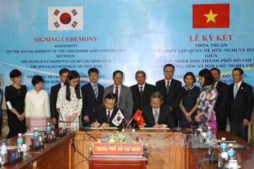 Phó Chủ tịch UBND Tp.Hồ Chí Minh Lê Văn Khoa cùng Phó Thị trưởng thứ nhất Tp.Seoul Gyoung-Gee Liu thực hiện nghi thức ký kết thỏa thuận về thiết lập quan hệ hữu nghị và hợp tác giữa hai thành phố. Ảnh: Thanh Vũ-TTXVN