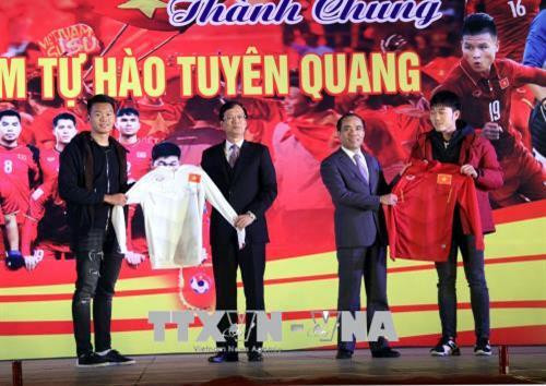 Hai tuyển thủ U23 Lương Xuân Trường, Nguyễn Thành Trung tặng chiếc áo đấu có chữ ký cho lãnh đạo tỉnh Tuyên Quang. Ảnh: Quang Cường – TTXVN