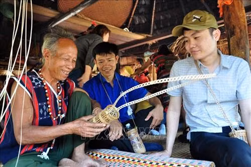Người Cơ tu ở xã Tà Bhing làm những chiếc rọ bằng sợi mây dùng đựng chai nước để bán cho khách du lịch. Ảnh: Đỗ Trưởng - TTXVN