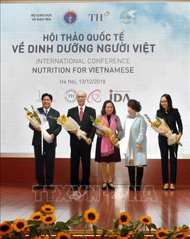 Bà Thái Hương - người sáng lập Tập đoàn TH true MILK tăng hoa chúc mừng các đại biểu tham dự hội thảo . Ảnh: Dương Ngọc - TTXVN