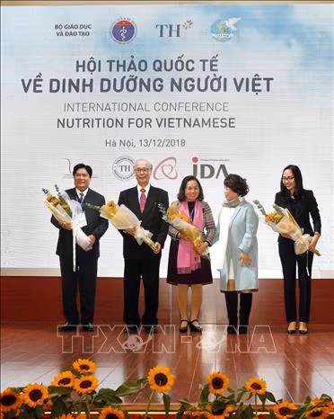 Bà Thái Hương - người sáng lập Tập đoàn TH true MILK tăng hoa chúc mừng các đại biểu tham dự hội thảo . Ảnh: Dương Ngọc - TTXVN