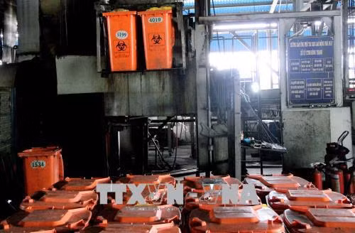 Vận hành dây chuyển xử lý rác thải nguy hại bằng công nghệ tự động. Ảnh: Xuân Dự - TTXVN