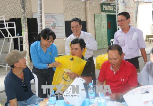 Lãnh đạo Liên đoàn Lao động Thành phố Hồ Chí Minh thăm hỏi, tặng quà công nhân bị tai nạn lao động tại buổi họp mặt. Ảnh: Thanh Vũ-TTXVN