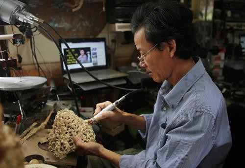 Ông Đoàn Minh Căn chế tác các chi tiết của lồng chim.