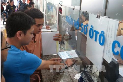 Người dân thực hiện bấm biển số tại 282 Nơ Trang Long, quận Bình Thạnh. Ảnh: Hoàng Hải-TTXVN