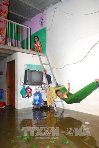 Nước ngập vào phòng trọ trên địa bàn phường Tam Phú, quận Thủ Đức. Ảnh: Mạnh Linh-TTXVN