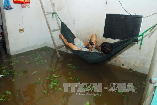 Công nhân thuê phòng trọ trên địa bàn phường Tam Phú, quận Thủ Đức phải căng võng lên cao do nước vẫn chưa rút. Ảnh: Mạnh Linh-TTXVN