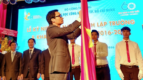 Phó Thủ tướng Chính phủ Vũ Đức Đam gắn Huân chương Độc lập hạng Ba lên lá cờ truyền thống của trường Đại học Công nghiệp Thành phố Hồ Chí Minh. Ảnh: Thế Anh- TTXVN