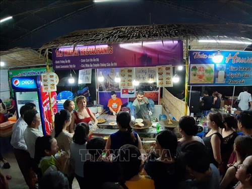 Khách thập phương vẫn tấp nập thưởng thức các loại bánh trong đêm bế mạc lễ hội. Ảnh: Ánh Tuyết - TTXVN