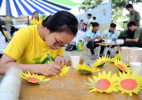 Các sinh viên tình nguyện tham gia viết ước mơ lên hoa hướng dương tại ngày hội. Ảnh: An Hiếu - TTXVN