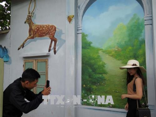 Du khách chụp ảnh tại làng Bích họa. Ảnh: TTXVN Du khách chụp ảnh tại làng Bích họa. Ảnh: TTXVN