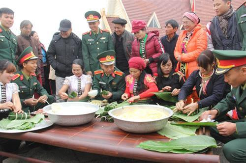 Đồng bào và các chiến sỹ cùng tham gia gói bánh chưng tặng cho người nghèo tại Làng Văn hóa - Du lịch các dân tộc Việt Nam trong chương trình "Gói bánh chưng xanh cùng người nghèo ăn Tết” năm 2018. Ảnh: Phạm Hương