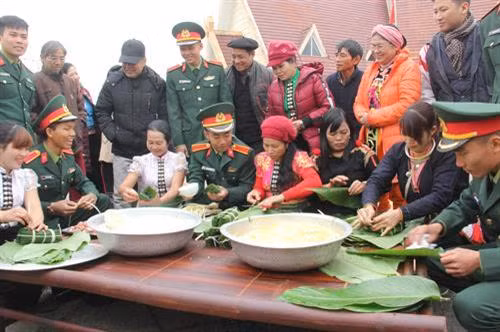 Đồng bào và các chiến sỹ cùng tham gia gói bánh chưng tặng cho người nghèo tại Làng Văn hóa - Du lịch các dân tộc Việt Nam trong chương trình "Gói bánh chưng xanh cùng người nghèo ăn Tết” năm 2018. Ảnh: Phạm Hương