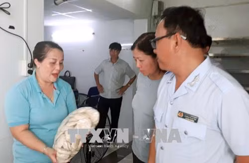 Chủ cơ sở sản xuất giò chả Hiền Khánh giải trình với Đoàn kiểm tra về nguồn gốc nguyên liệu làm ra sản phẩm giò chả. Ảnh: Đinh Hằng – TTXVN