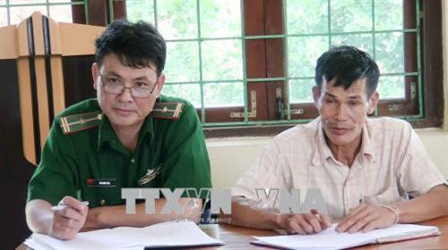 Phó Bí thư Đảng ủy xã Thượng Trạch, huyện Bố Trạch, tỉnh Quảng Bình (áo xanh, bên trái). Ảnh: Võ Dung - TTXVN