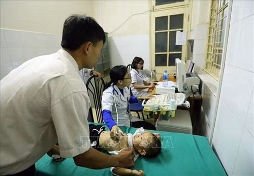 Các bác sĩ khám siêu âm cho trẻ. Ảnh: Phan Tuấn Anh - TTXVN